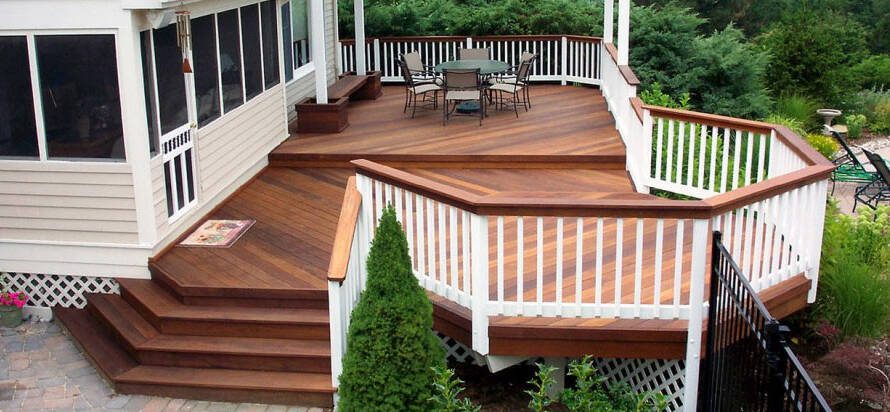 A deck with stairs and a table in the middle.