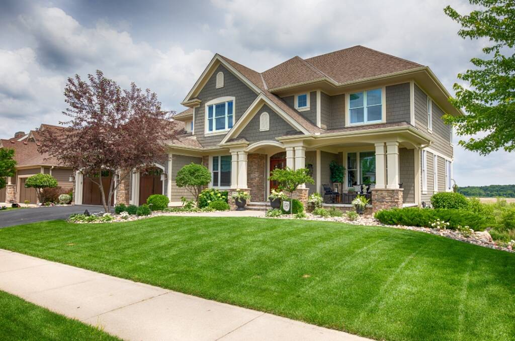 A large house with green grass on the front lawn.