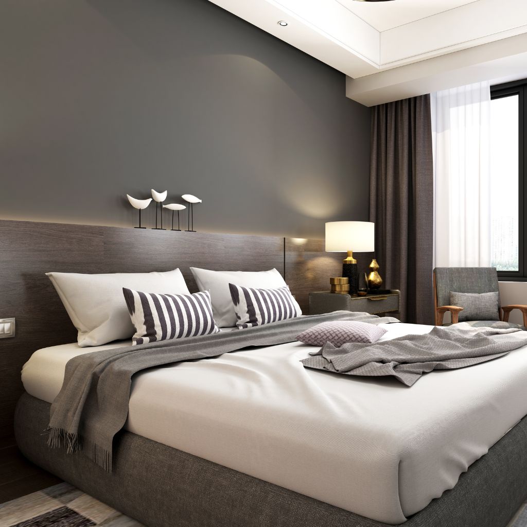 A bedroom with a large bed and grey walls.