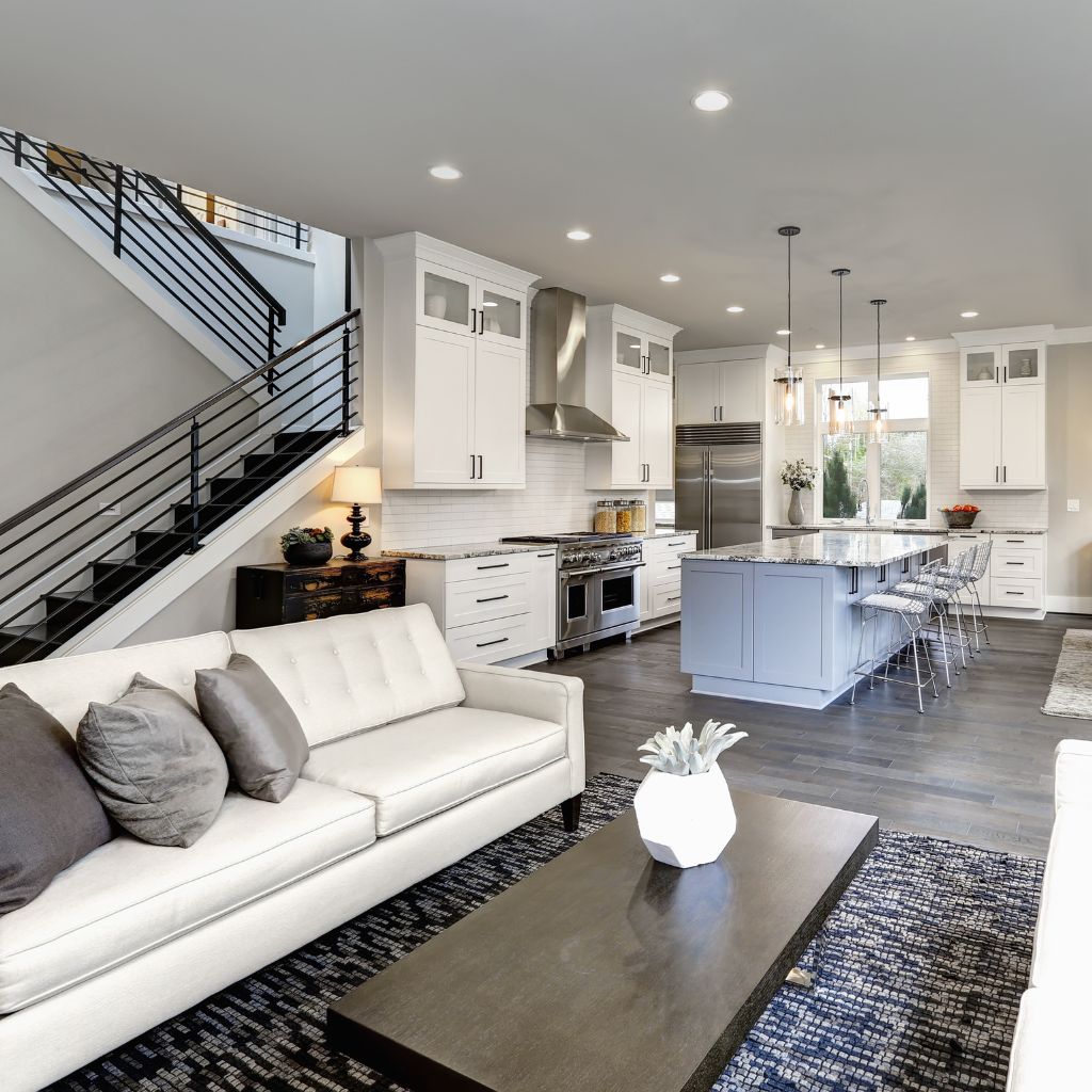 A living room with white furniture and black carpet.